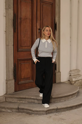 a lady in a striped top and a pair of black pants